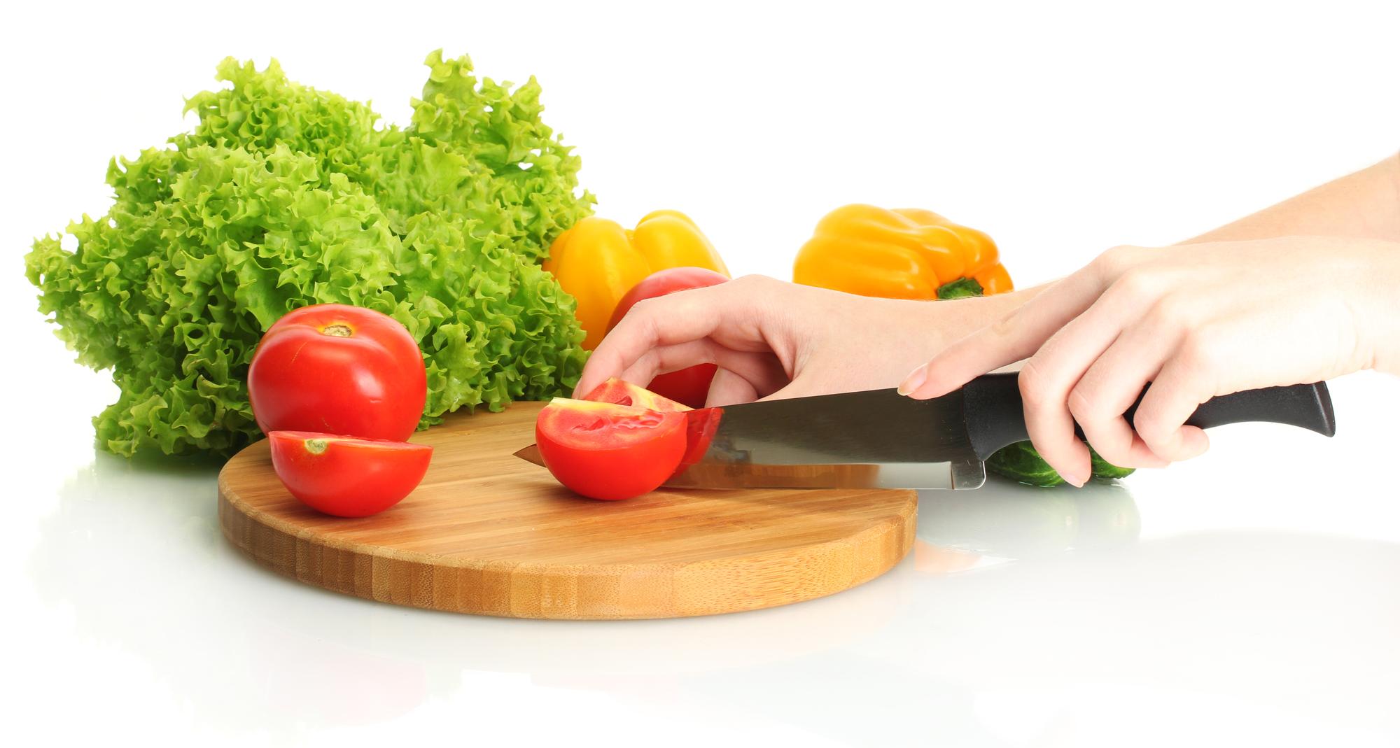 Hands preparing vegetables with chef knife